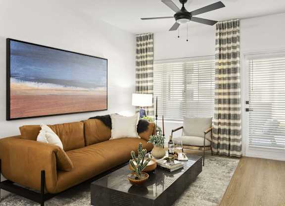 A living room with a brown couch, a coffee table, and a painting on the wall.