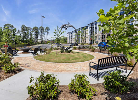 A park with a bench and a walking path.