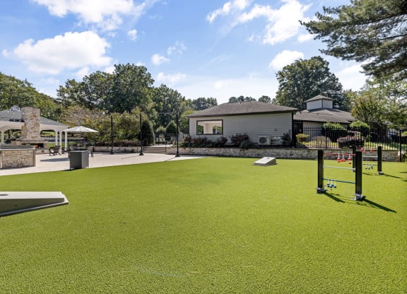 a putting green with a house in the background at View at Lake Lynn, Raleigh