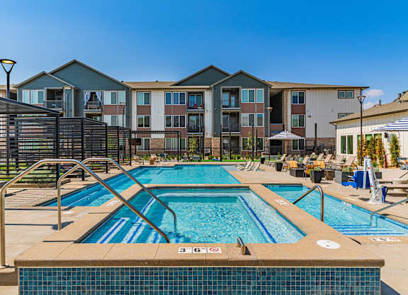 A large swimming pool in front of apartment buildings.