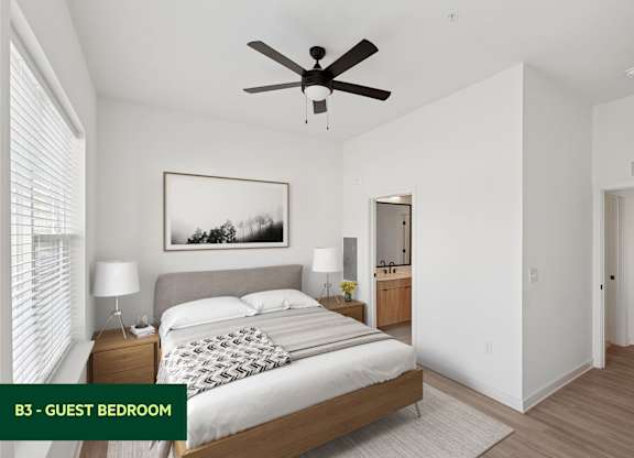 A guest bedroom with a large bed and a ceiling fan.