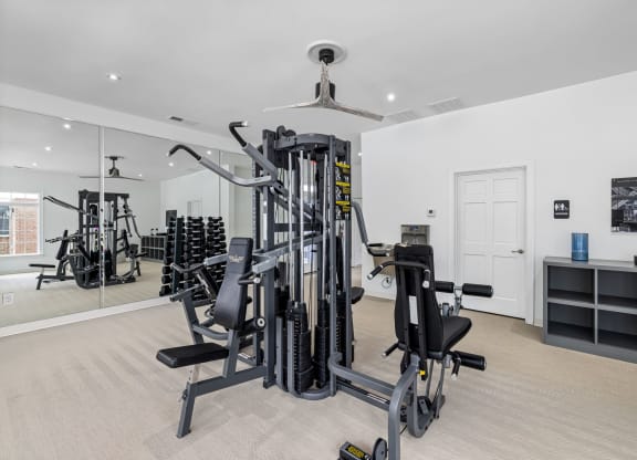 a gym with weights and cardio equipment in a home with a glass door  at Mariners Crossing, Raleigh, NC 27612