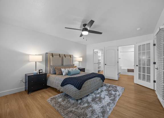 A bedroom with a bed, dresser, and ceiling fan.
