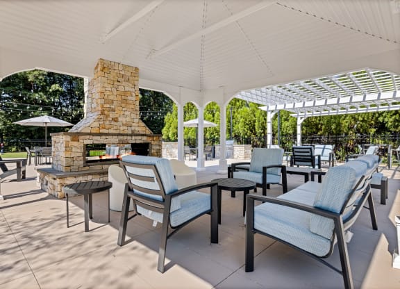 the outdoor patio has a fireplace and tables with chairs at View at Lake Lynn, Raleigh, NC 27613