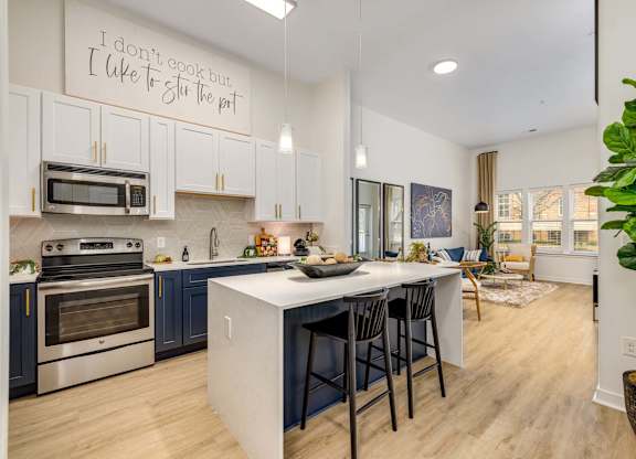 A greatroom and kitchen with center island, offered at Midtown 205, recognized as best apartments in Charlotte, NC.