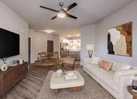 A living room with a white couch and a ceiling fan.