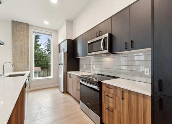 A modern kitchen with wooden cabinets and black appliances. at Ion Town Center, Shorelin