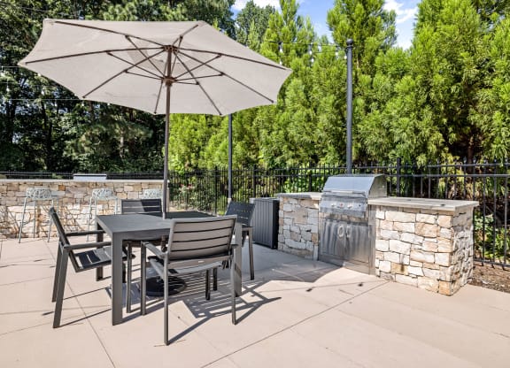 a patio with a table and chairs and an umbrella at View at Lake Lynn, North Carolina, 27613
