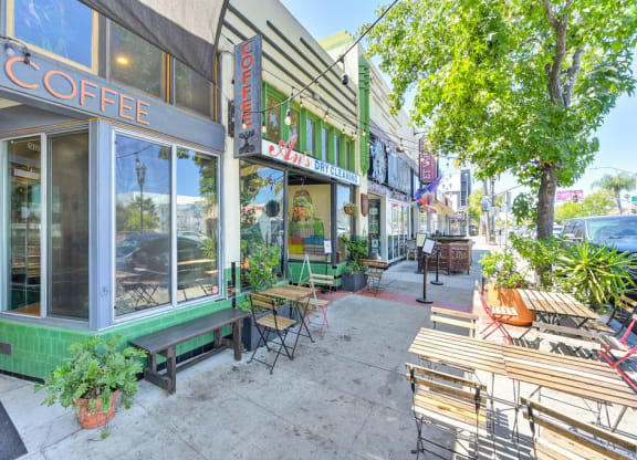 a sidewalk outside of a coffee shop with benches