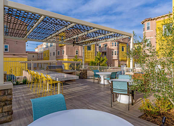 A patio with a table and chairs under a roof.