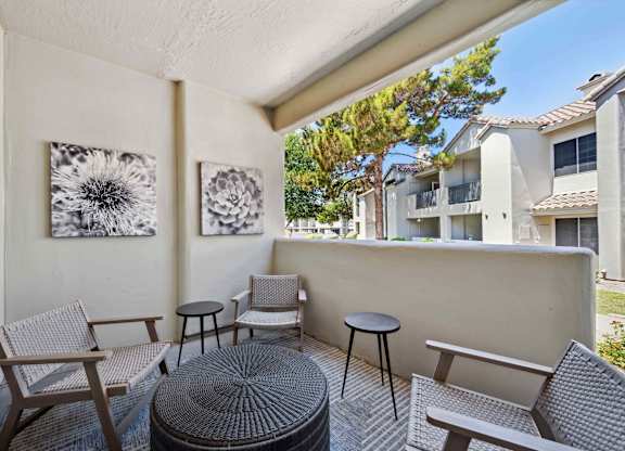 A patio with a table and chairs and a view of a building.