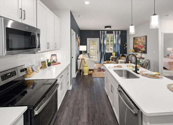 A modern kitchen with dark wood floors and white cabinetry.