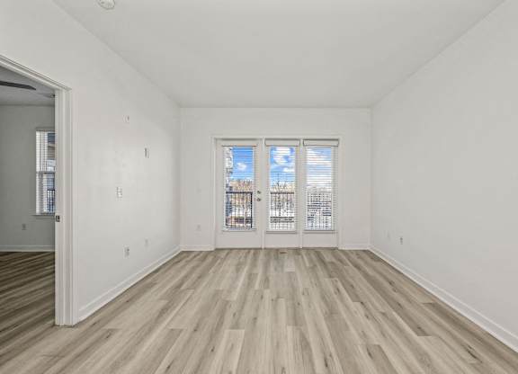 A room with a window and wooden flooring.