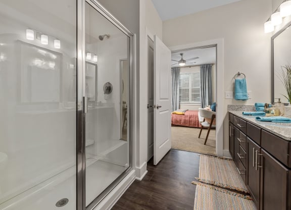 furnished Primary suite bathroom with dual vanity and granite countertops
