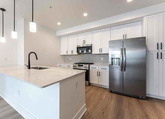 kitchen at The Vive Collection, featuring white cabinets and a kitchen island.