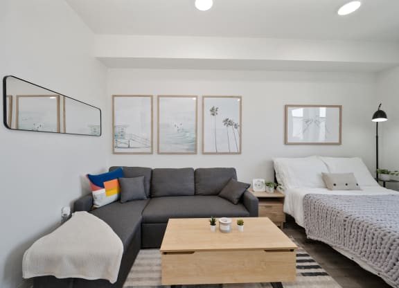 a living room with a couch and a coffee table and a bed