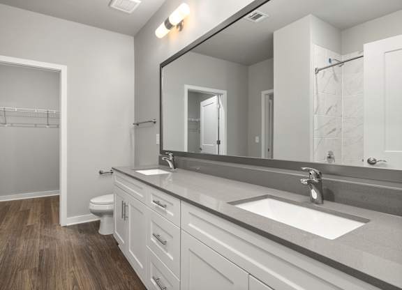 A bathroom with a white sink and a large mirror.