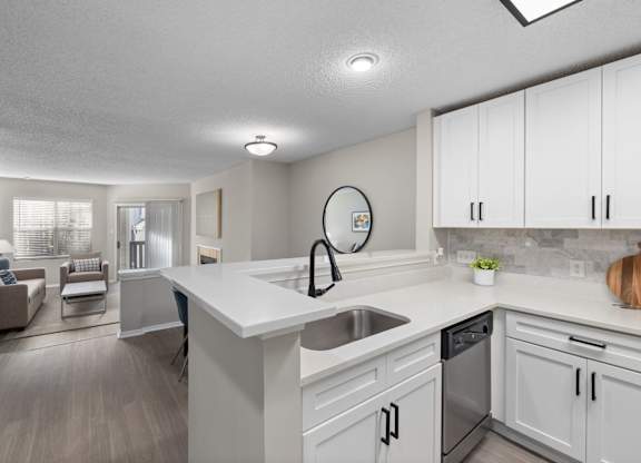A modern kitchen with white cabinets and a large island.