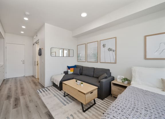 a living room with a couch and a table     and a bed