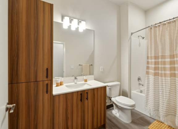 A bathroom with a toilet, sink, and shower. at Ion Town Center, Shoreline, WA 98133