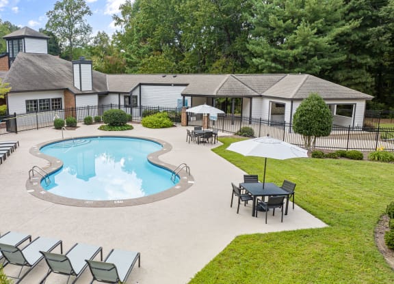 an outdoor pool with chairs and a house in the background at View at Lake Lynn, North Carolina, 27613