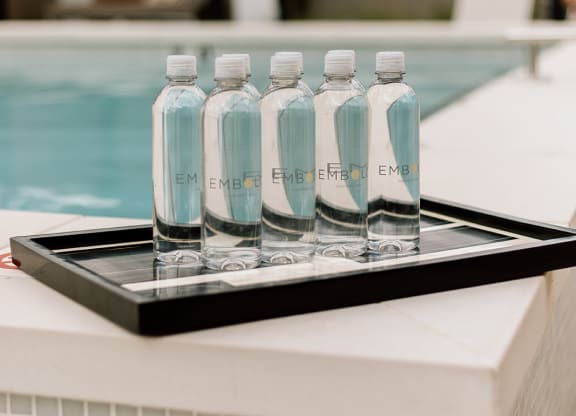 a tray of water bottles sits on the edge of a pool  at Embold, Lehi, UT