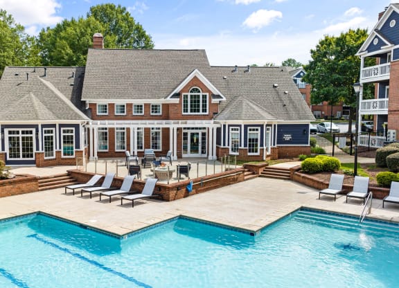 a large pool with chairs in front of a large house at Mariners Crossing, Raleigh North Carolina