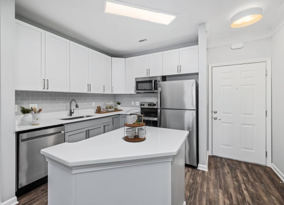 a kitchen with white cabinetry and stainless steel appliances