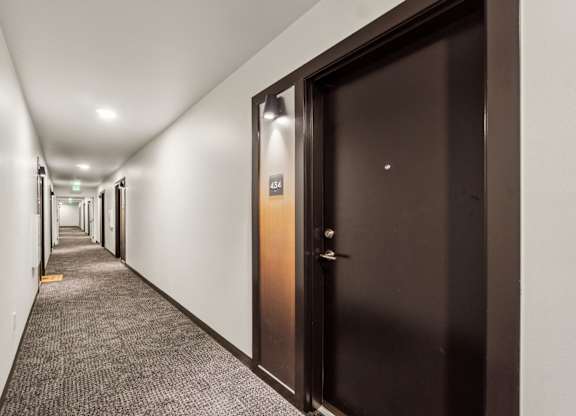 A hallway with a brown door and a sign that says  at Ion Town Center,  98133