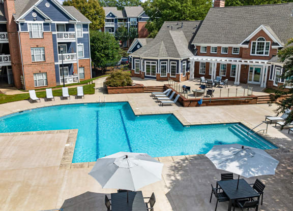 an aerial view of a swimming pool with chairs and umbrellas and a house at Mariners Crossing, Raleigh, 27613