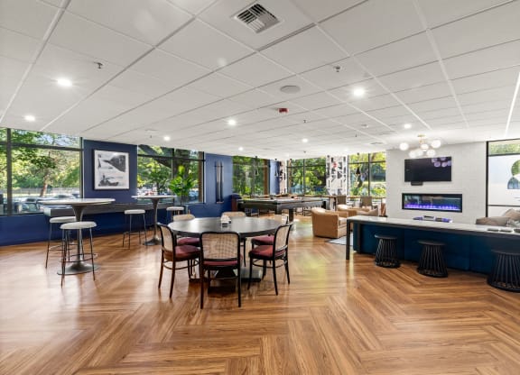 a dining room with tables and chairs and a bar with a television