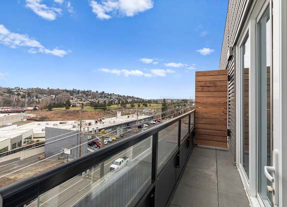 A balcony with a view of a highway and buildings.