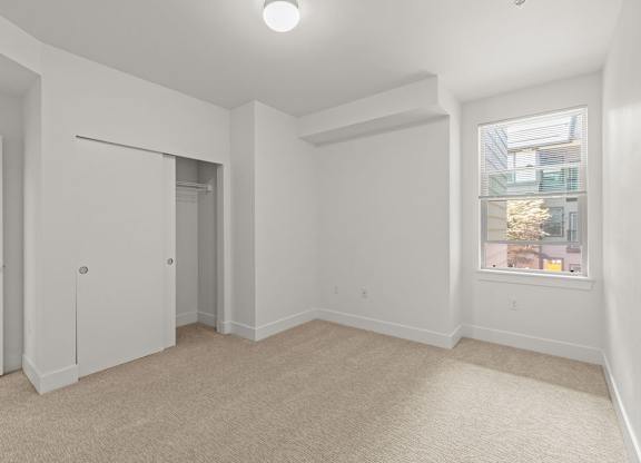 Empty bedroom with walk-in closet and carpet at Six Oaks Apartments, Washington