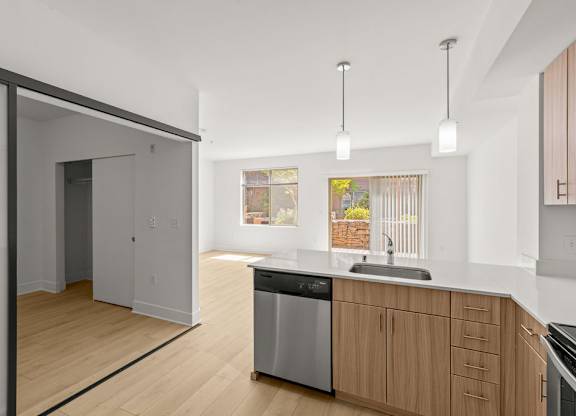Kitchen with wood cabinets and sliding door entry at Six Oaks Apartments, Bothell, WA 98011