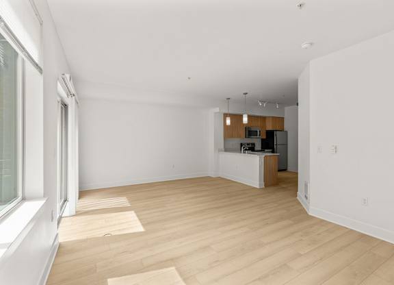 Open living room with kitchen and light wood floors at Six Oaks Apartments, Washington, 98011