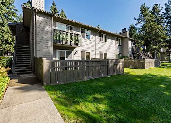 Two story apartment building with private patio and fenced yard at Scout Apartments, Kirkland, 98034