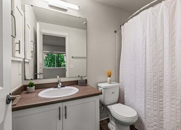 Bathroom with white vanity and wood countertop at Hidden River Townhomes Apartments, Washington, 98034