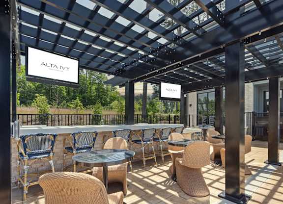 A patio with tables and chairs under a roof with