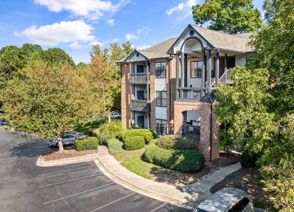 the view of an apartment building with a parking lot and trees at View at Lake Lynn, North Carolina, 27613
