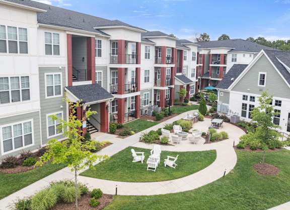 Apartment complex with a green lawn and trees.