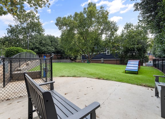 a park with a bench and a chain link fence at Mariners Crossing, Raleigh