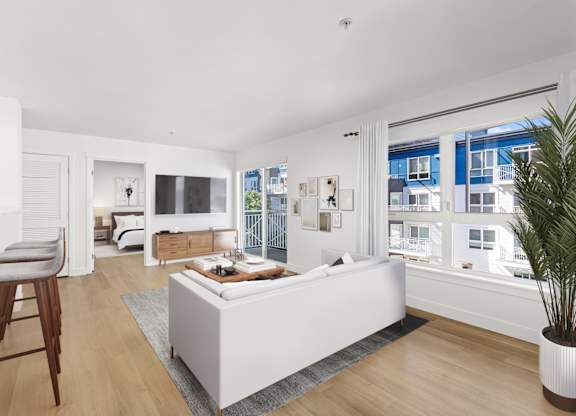 A white bedroom with a large bed and a wooden chair.