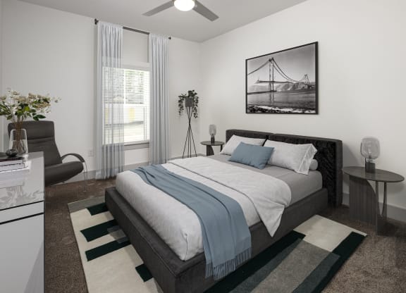 an open bedroom with a bed and a couch and a window