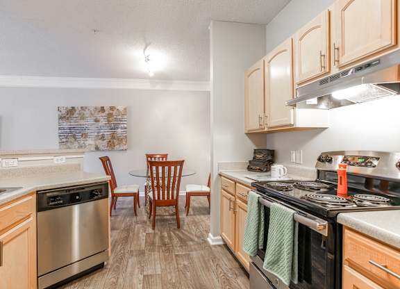 A kitchen with wooden cabinets and a stainless steel oven.
