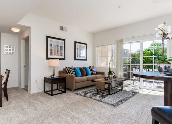 A living room with a couch, a chair, a coffee table, and a lamp.