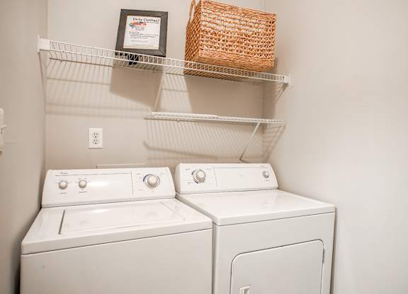Two white washing machines in a laundry room.