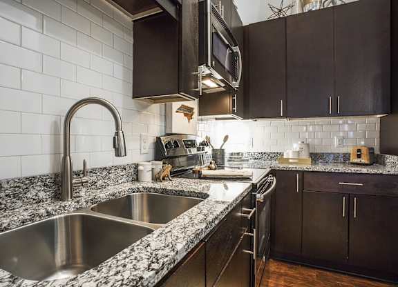 A kitchen with a sink and a microwave.