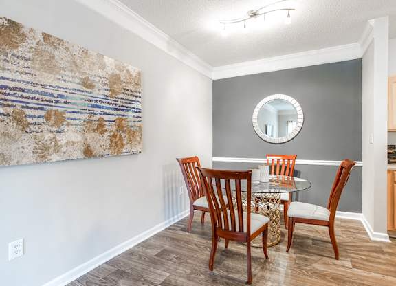 A dining room with a table set for four.