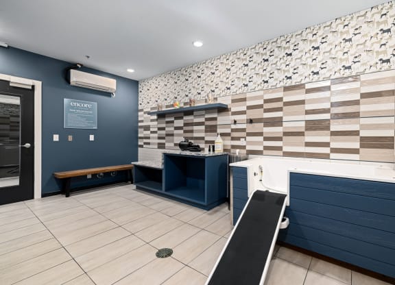 a room with a desk and a bench in front of a wall with a checkered