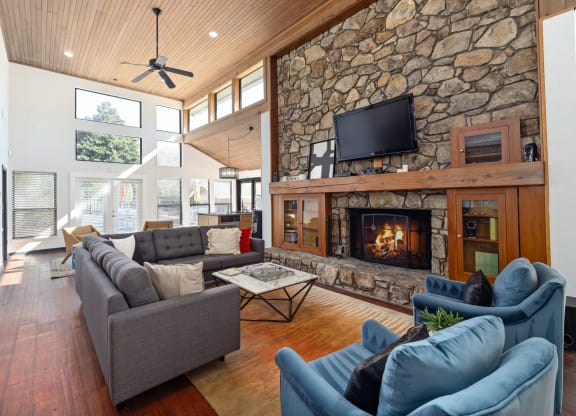a large living room with a stone fireplace and couches